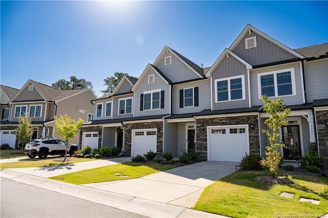 multi unit property featuring a garage, a front lawn, stone siding, board and batten siding, and concrete driveway