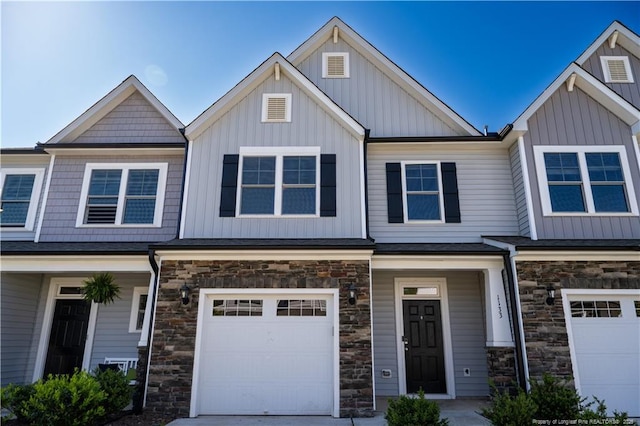 view of front facade with an attached garage, board and batten siding, and stone siding