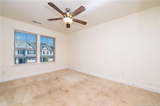 carpeted empty room with baseboards, visible vents, and ceiling fan