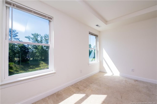 carpeted empty room featuring visible vents and baseboards