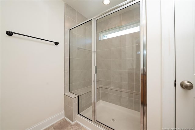 bathroom featuring baseboards and a stall shower