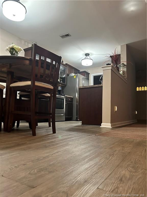 dining space with visible vents and wood finished floors