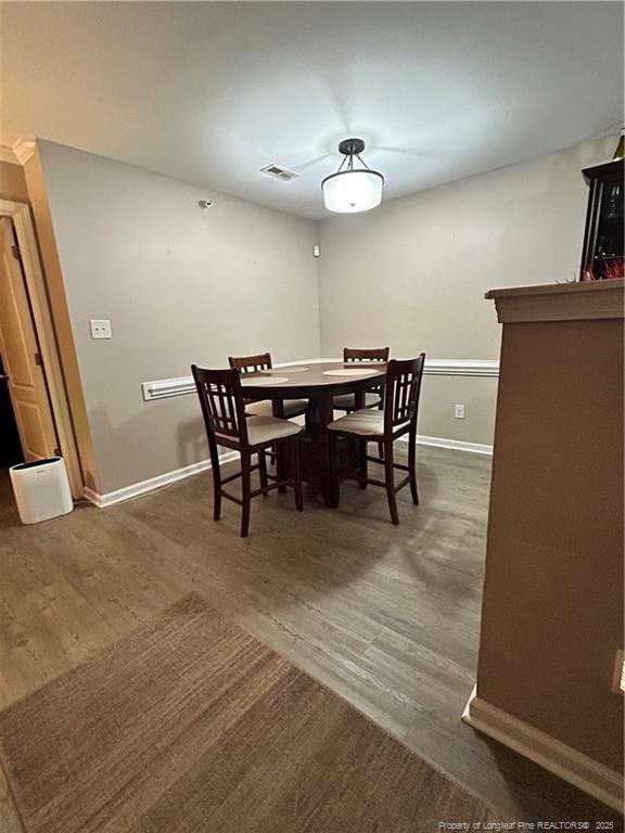 dining area featuring baseboards, dark wood finished floors, and visible vents