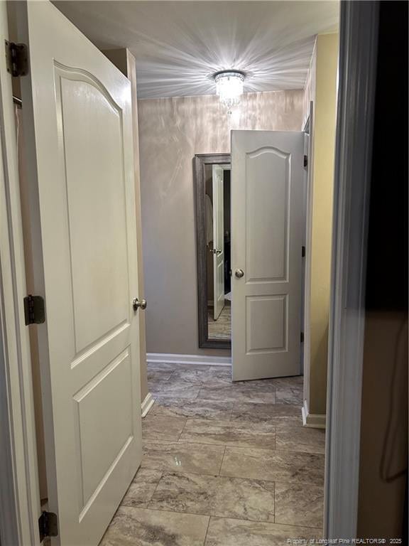 hall featuring baseboards