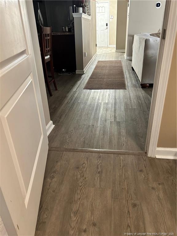 hallway with baseboards and wood finished floors