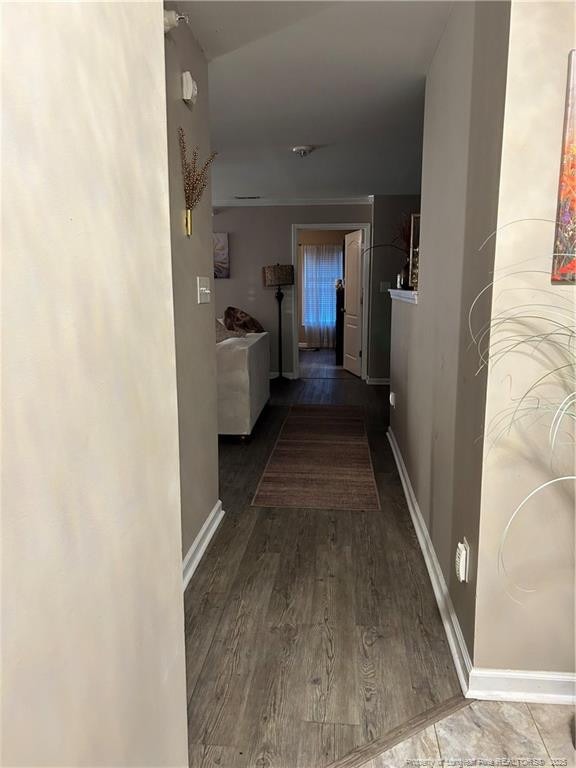 hall featuring baseboards and wood finished floors