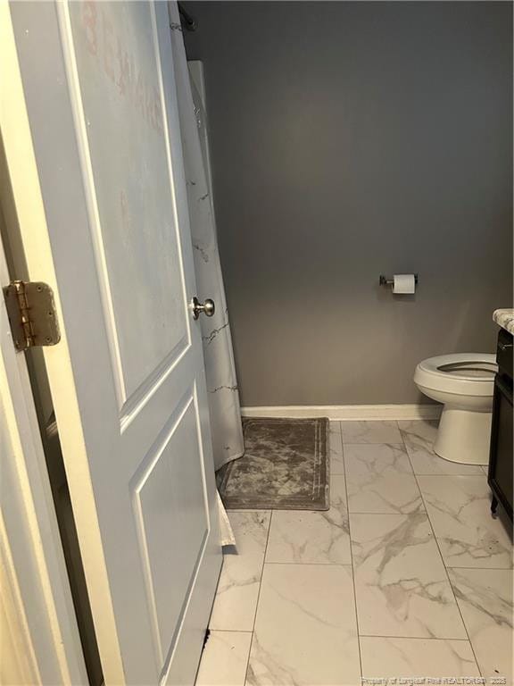 full bath featuring toilet, baseboards, marble finish floor, and vanity