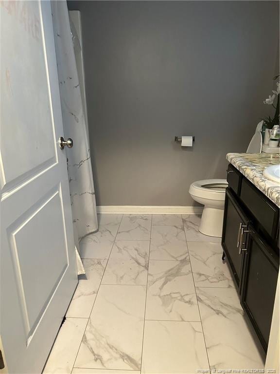 full bathroom with toilet, baseboards, marble finish floor, and vanity