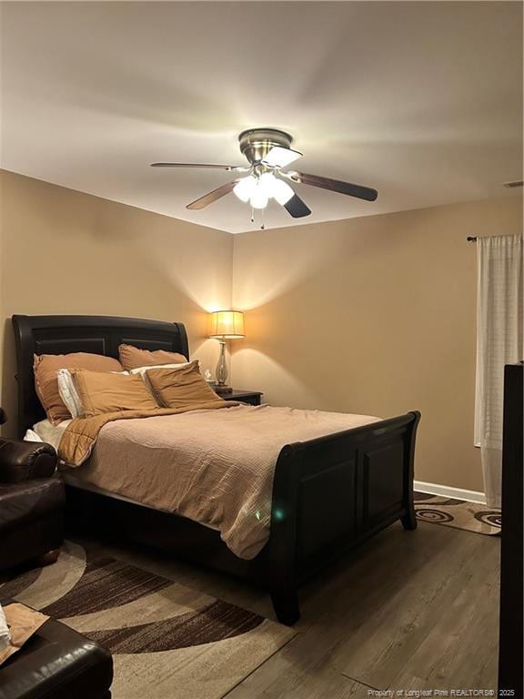 bedroom with baseboards, a ceiling fan, and dark wood-style flooring