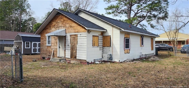 511 W Northrop St, Saint Pauls, NC 28384 - bungalow-style house featuring fence, a storage unit, an outdoor structure, and a shingled roof