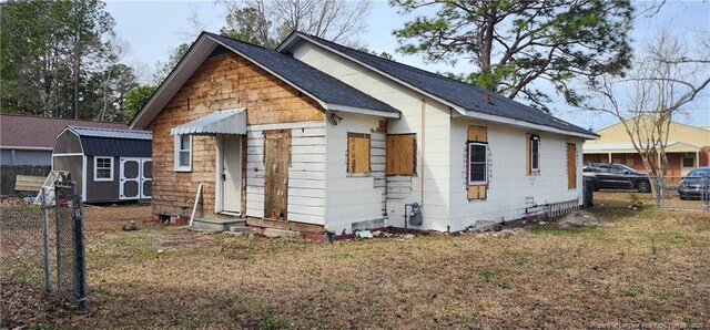 511 W Northrop St, Saint Pauls, NC 28384 - bungalow-style house featuring fence, a storage unit, an outdoor structure, and a shingled roof