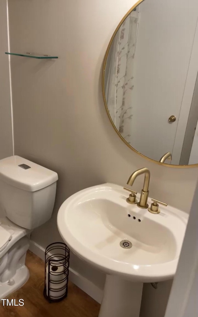 bathroom with a sink, wood finished floors, and toilet
