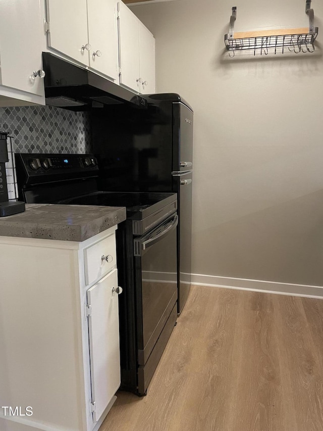kitchen featuring white cabinets, light wood-style floors, baseboards, decorative backsplash, and black range with electric stovetop
