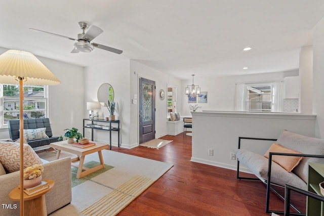 living area with recessed lighting, baseboards, wood finished floors, and ceiling fan with notable chandelier
