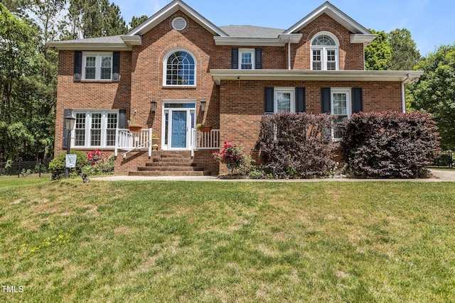 view of front of house featuring a front lawn and brick siding