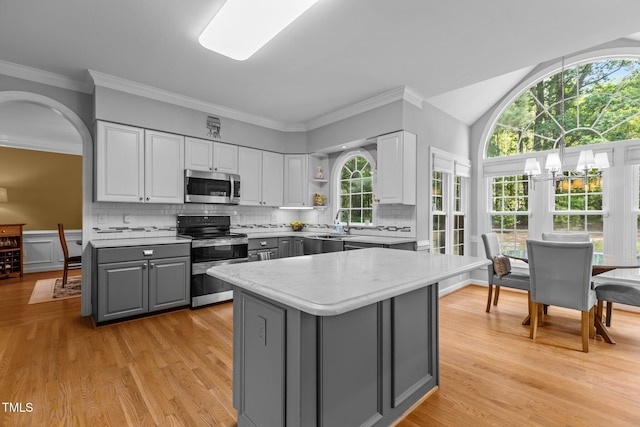 kitchen with a healthy amount of sunlight, appliances with stainless steel finishes, white cabinets, and gray cabinetry