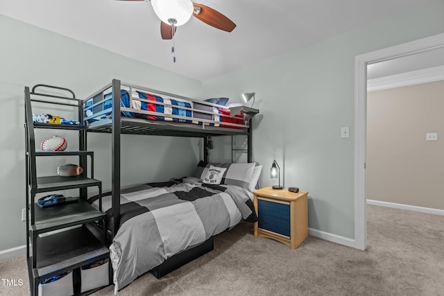 carpeted bedroom featuring baseboards, ornamental molding, and ceiling fan