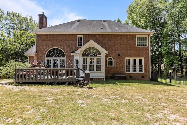 rear view of house featuring a chimney, a yard, fence, crawl space, and a wooden deck