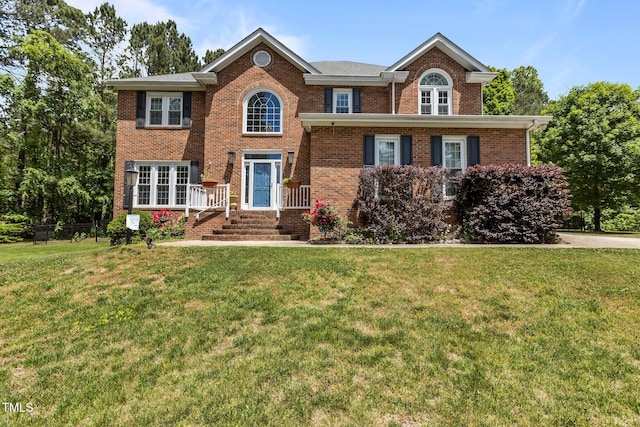 view of front of home with a front yard and brick siding