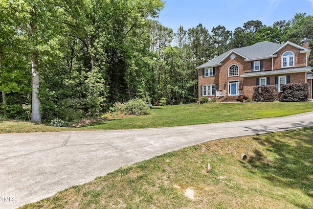 view of front of property featuring a front yard and brick siding