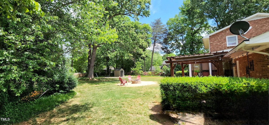 view of yard with a storage unit, an outdoor structure, and an outdoor fire pit