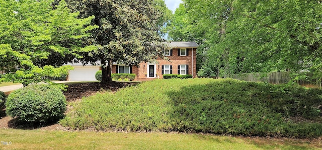 view of front of property featuring concrete driveway, brick siding, and fence