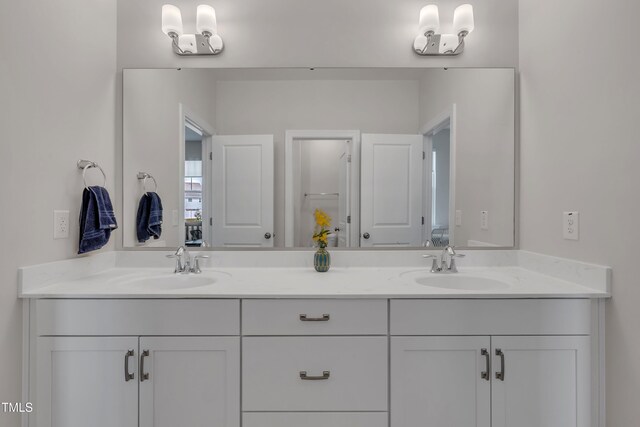 full bathroom with double vanity and a sink