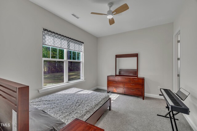 bedroom with light colored carpet, baseboards, visible vents, and ceiling fan