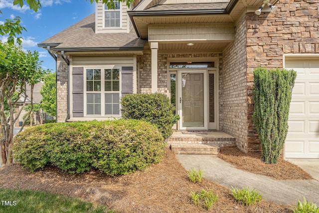 106 Jordan Creek Dr, Jamestown, NC 27282 - view of exterior entry featuring a garage, a shingled roof, and stone siding