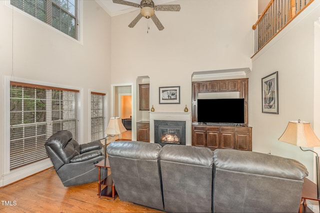 106 Jordan Creek Dr, Jamestown, NC 27282 - living area with crown molding, a towering ceiling, wood finished floors, a fireplace, and ceiling fan