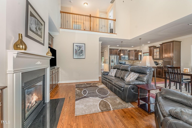 106 Jordan Creek Dr, Jamestown, NC 27282 - living area featuring crown molding, baseboards, a glass covered fireplace, and wood finished floors