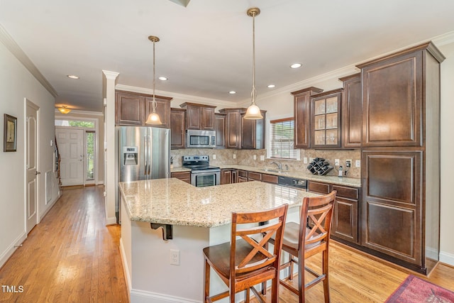 106 Jordan Creek Dr, Jamestown, NC 27282 - kitchen with dark brown cabinets, appliances with stainless steel finishes, a healthy amount of sunlight, tasteful backsplash, and a kitchen island