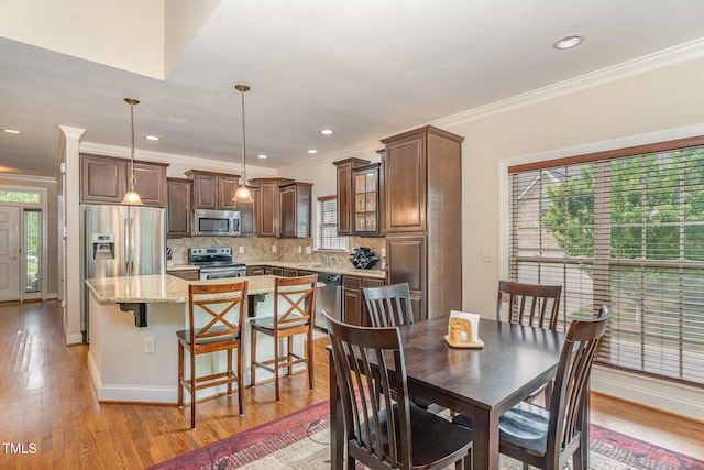 106 Jordan Creek Dr, Jamestown, NC 27282 - dining space with ornamental molding, a healthy amount of sunlight, and light wood finished floors