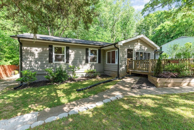 single story home featuring a wooden deck, fence, and a front yard