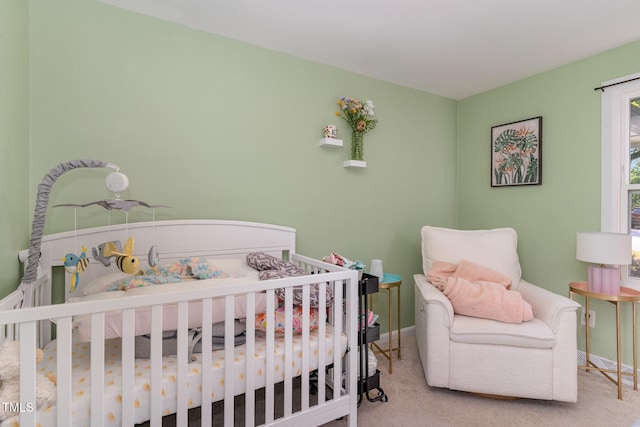 carpeted bedroom with a nursery area and baseboards