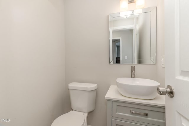 half bath featuring vanity and toilet