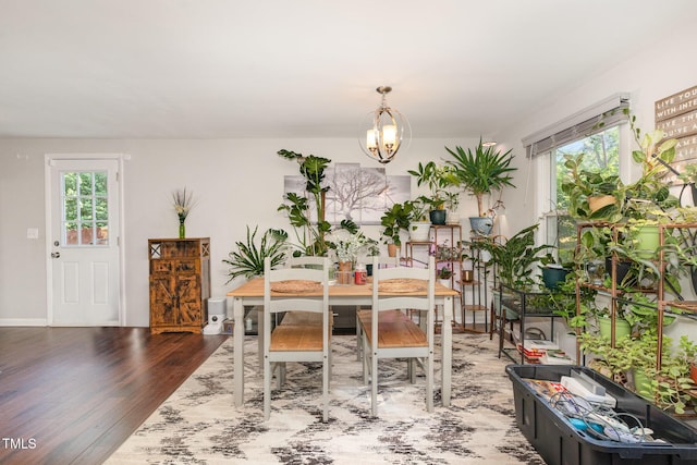 dining room featuring baseboards, a chandelier, and wood finished floors