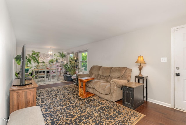 living room with baseboards, dark wood finished floors, and a notable chandelier