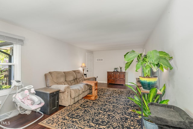 living area with baseboards and wood finished floors