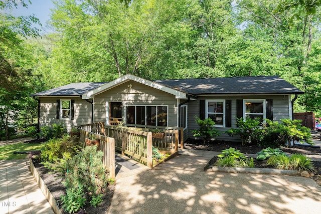 single story home featuring roof with shingles and a deck