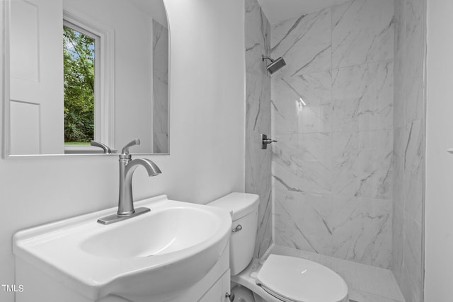 bathroom featuring vanity, a marble finish shower, and toilet