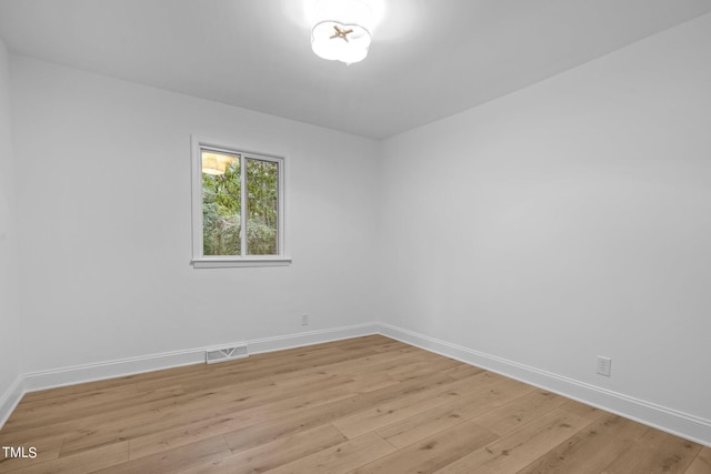 unfurnished room with baseboards, visible vents, and light wood finished floors