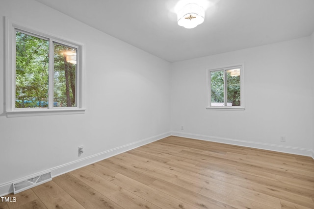 unfurnished room with baseboards, visible vents, and light wood-style flooring