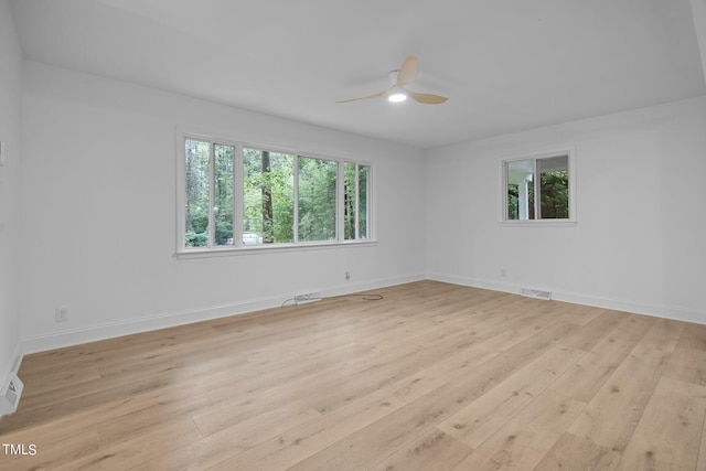 spare room with a ceiling fan, visible vents, a wealth of natural light, and light wood-style floors