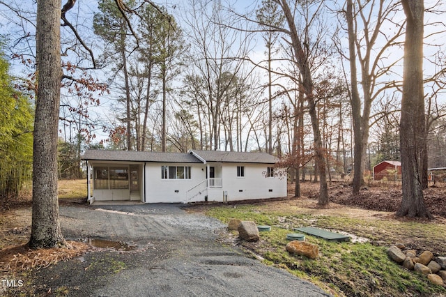 view of front facade featuring roof with shingles and gravel driveway