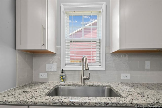 5113 Boxcut Ln, Hope Mills, NC 28348 - kitchen with a sink, white cabinetry, backsplash, and light stone counters
