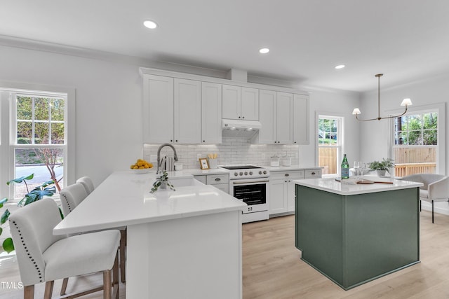 801 N Elm St, Durham, NC 27701 - kitchen featuring an inviting chandelier, white electric range oven, under cabinet range hood, white cabinets, and a sink
