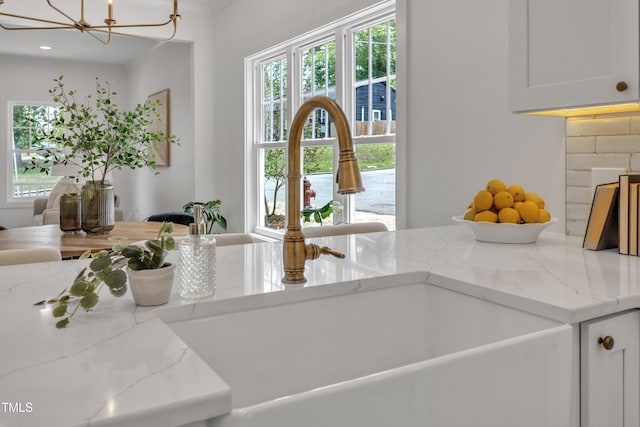 801 N Elm St, Durham, NC 27701 - interior space featuring white cabinets, a notable chandelier, a sink, and light stone counters