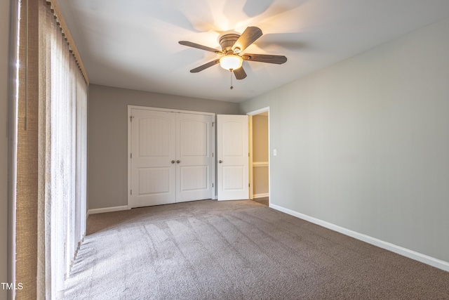 unfurnished bedroom with a ceiling fan, baseboards, carpet, and a closet
