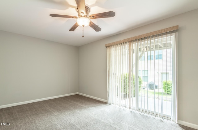 carpeted spare room with baseboards and a ceiling fan